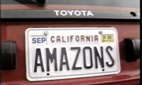 Kim Poteat, who pulls her red car, license plate "AMAZONS" into a parking lot. She proceeds to enter a beauty salon, where this gorgeous tall brunette will get a pedicure. What a great opportunity for Kim to show off her sleek, shapely legs! She is solid from head to toe, and you can just see those muscular calves wanting to pop right out of her legs. Her athletic background includes twelve years of ballet which explains her wonderful physique. She wears a white dress which adds spectacular contrast to her bronzed silky smooth skin. Kim constantly flexes her toes in and out, revealing more and more of those calves. But wait!...